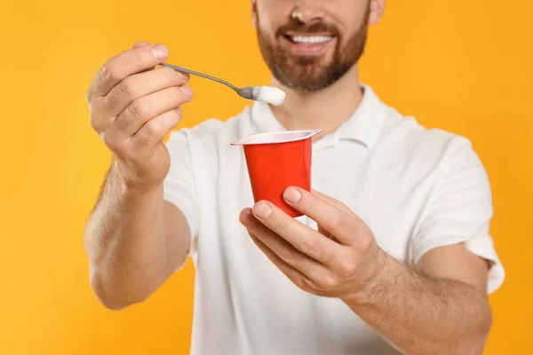 Homem Com Delicioso Iogurte Colher Fundo Amarelo Close — Fotografia de Stock