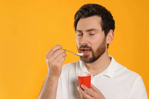 Handsome Man Eating Delicious Yogurt Yellow Background Space Text — Stock Photo, Image