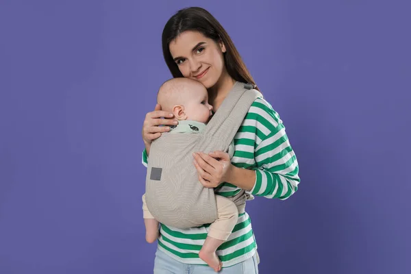 Mor Håller Sitt Barn Lyftsele Baby Bärare Lila Bakgrund — Stockfoto
