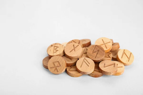 Pile of wooden runes on white background