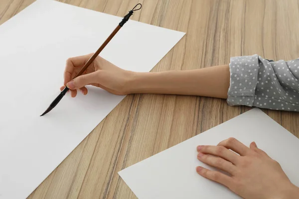 木制桌旁空白纸上水彩画的女人 — 图库照片