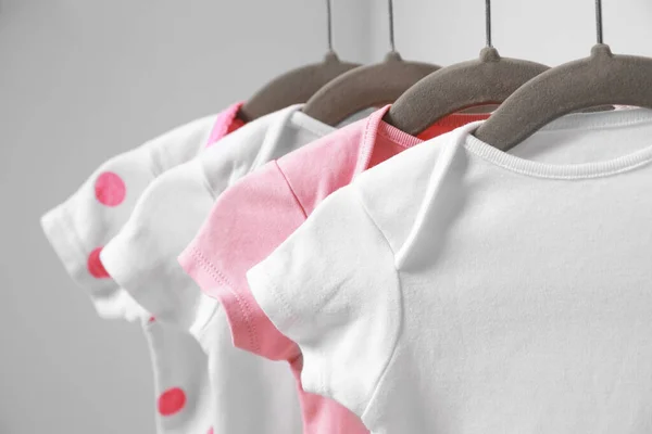 Hangers Med Baby Bodysuits Vit Bakgrund Närbild — Stockfoto