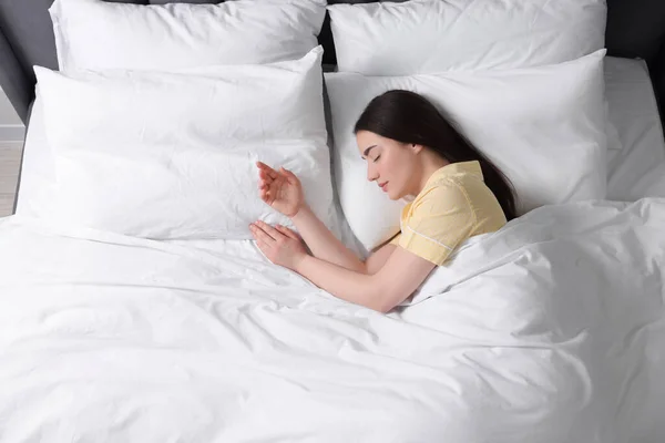 美しい若い女性が柔らかいベッドで寝て 上記のビュー — ストック写真