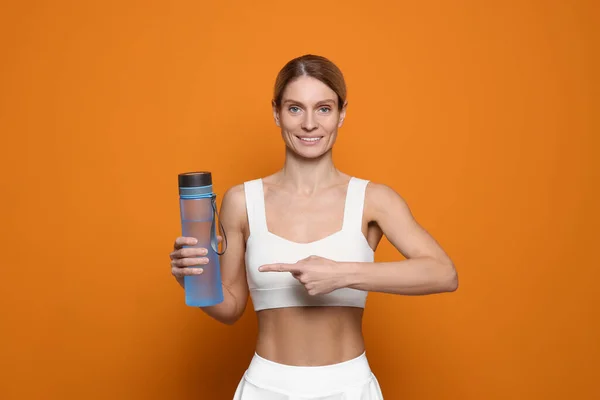 橙色底色水瓶的女运动员 — 图库照片