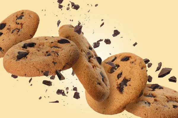 薄い金の背景に落ちるおいしいチョコレートチップクッキー — ストック写真