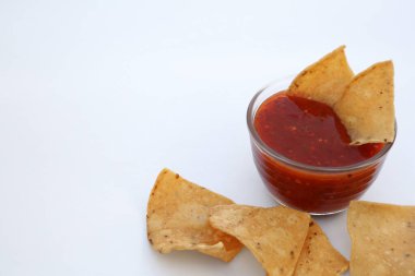 Tasty salsa sauce and tortilla chips on white background