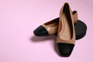 Soluk pembe arka planda bir çift yeni moda kare parmak bale ayakkabısı. Metin için boşluk