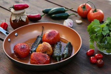 Ahşap masada salsa sosu malzemeli kızartma tavası.