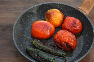 Ahşap masada salsa sosu malzemeli kızartma tavası.