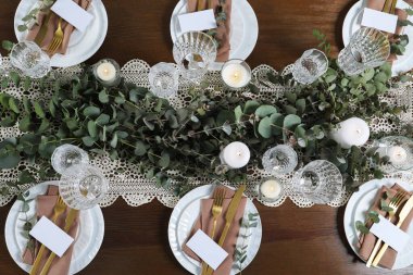 Güzel dekorlu ve boş kartlı lüks masa ayarları, düz yatış. Şenlikli yemek.