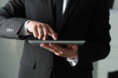 Kapalı alanda yeni tablet kullanan adamın yakın görüntüsü