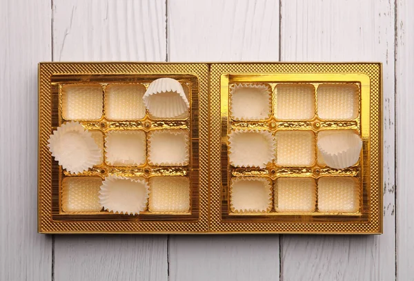 白い木製のテーブルの上にチョコレートキャンディーの空のボックス トップビュー — ストック写真