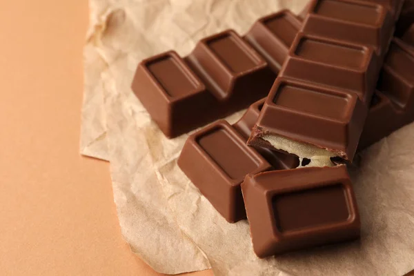 Perkamen Dengan Coklat Lezat Bar Pada Latar Belakang Coklat Muda — Stok Foto