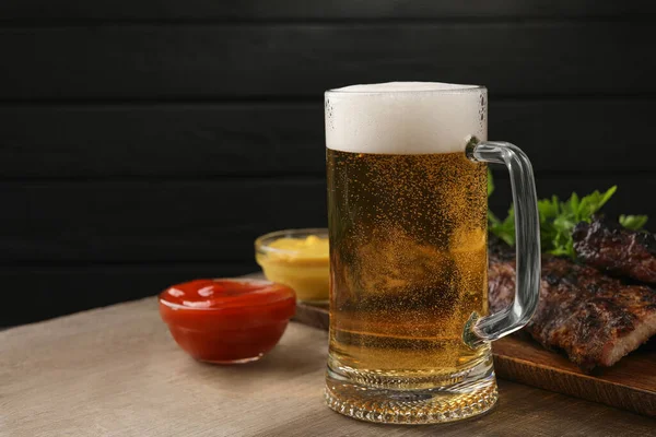 Beker Met Bier Heerlijke Gegrilde Ribbetjes Sauzen Houten Tafel Ruimte — Stockfoto