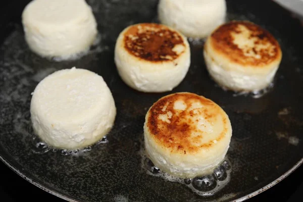 stock image Delicious cottage cheese pancakes in frying pan, closeup