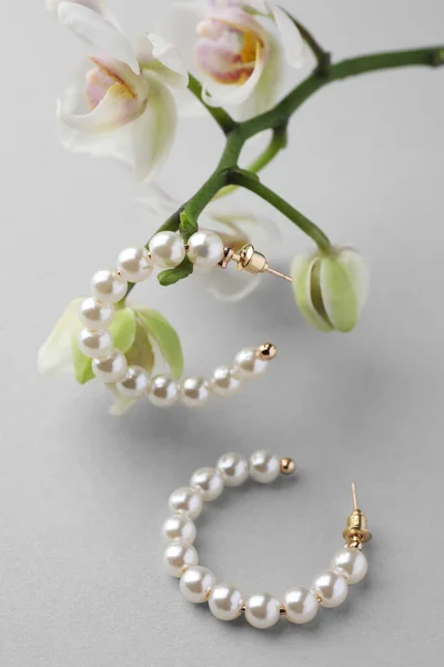 Eleganta Pärla Örhängen Och Orkidé Blommor Vit Bakgrund Närbild — Stockfoto