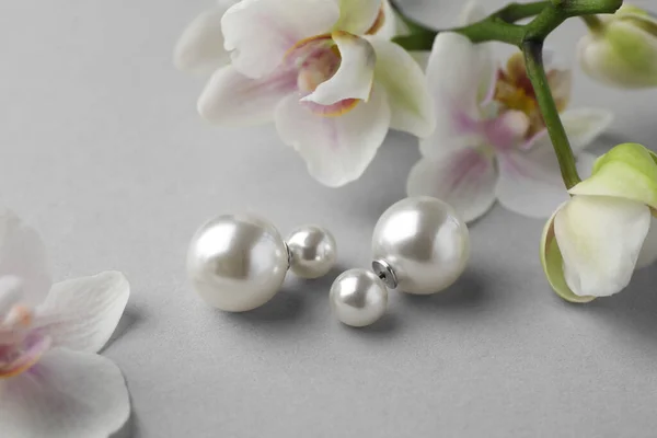 Elegante Perlenohrringe Und Orchideenblumen Auf Weißem Hintergrund Nahaufnahme — Stockfoto
