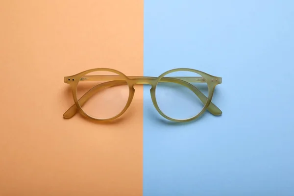 色背景に補正レンズを持つメガネ トップビュー — ストック写真