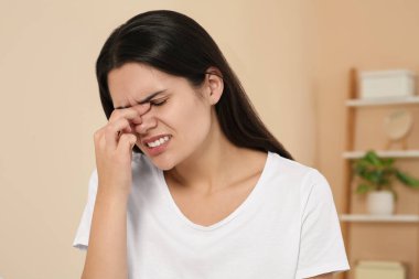 İçeride baş ağrısı çeken genç bir kadın. Hormonal bozukluklar