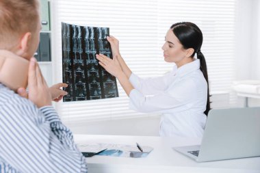 Boyun MR 'ı olan bir doktor klinikte görüntü danışmanlığı yapıyor.