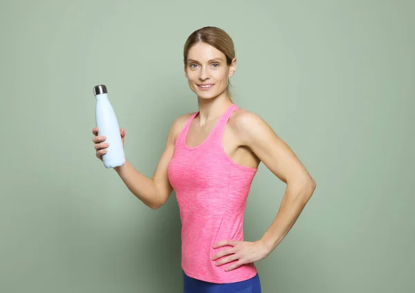 Sportlerin Mit Thermoflasche Auf Grünem Hintergrund — Stockfoto