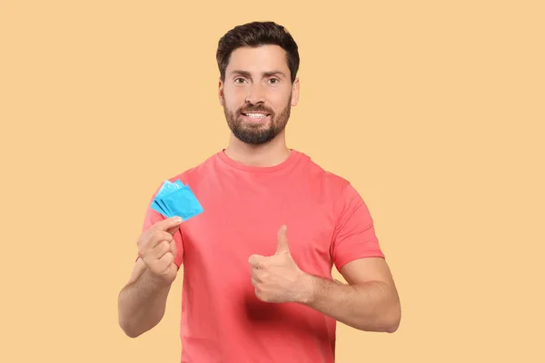 Homem Feliz Com Preservativos Mostrar Polegar Fundo Bege Sexo Seguro — Fotografia de Stock