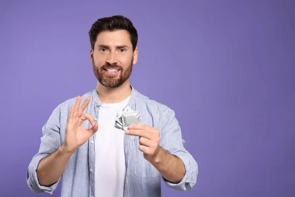 Man Condoms Showing Gesture Purple Background Space Text Safe Sex — Stock Photo, Image