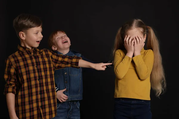 Boys Laughing Pointing Upset Girl Black Background Children Bullying — Stock Photo, Image