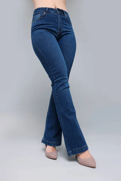 Vrouw Stijlvolle Jeans Grijze Achtergrond Close — Stockfoto