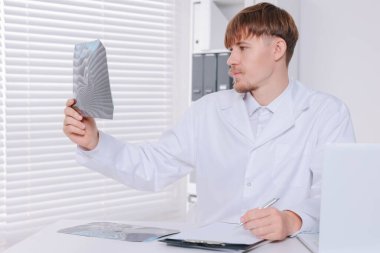 Doktor klinikte boyun MRI görüntüsünü inceliyor.