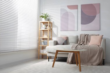 Şık bir oturma odası. Kanepe, sehpa ve ahşap raf.