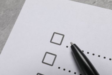 Kağıt kağıtlar, işaretli kutular ve açık gri masa üzerinde kalem, yakın plan. Kontrol Listesi