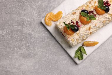 Mandalina dilimleri ve gri masadaki nane yapraklarıyla nefis bir kremalı pasta. Metin için boşluk