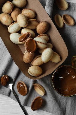 Lezzetli ceviz şekilli kurabiyeler. Yoğunlaştırılmış süt beyaz ahşap masada, düz yerde.