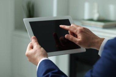 Kapalı alanda yeni tablet kullanan adamın yakın görüntüsü