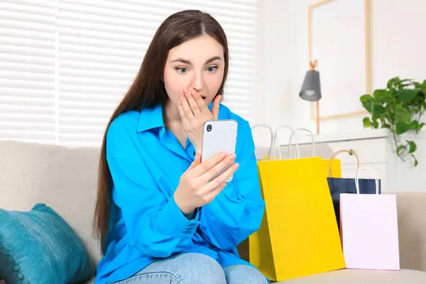 Promoção Especial Mulher Jovem Emocional Olhando Para Smartphone Sofá Dentro — Fotografia de Stock