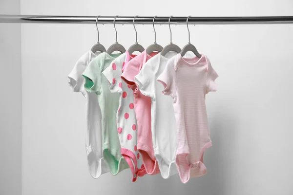 Baby Bodysuits Opknoping Rek Buurt Van Witte Muur — Stockfoto