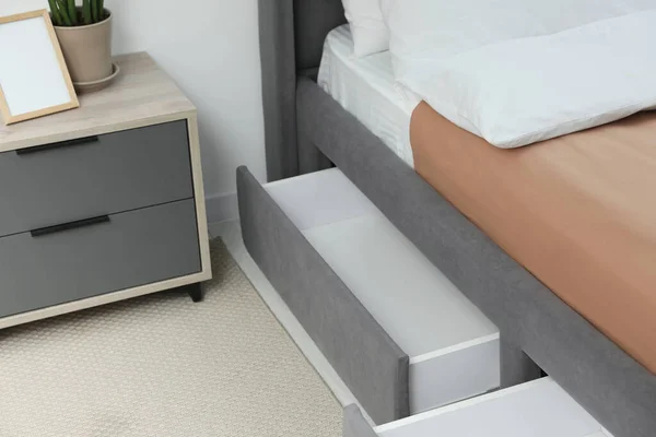 Storage drawers for bedding under modern bed in room