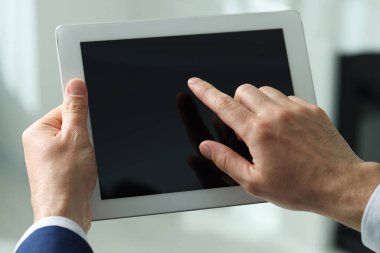 Kapalı alanda yeni tablet kullanan adamın yakın görüntüsü