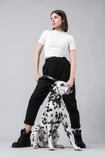 stock image Beautiful young woman with her adorable Dalmatian dog on light grey background. Lovely pet