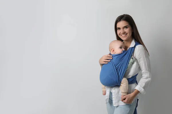 Moeder Houdt Haar Kind Draagdoek Babydrager Lichtgrijze Achtergrond Ruimte Voor — Stockfoto