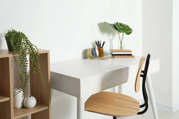 stock image Comfortable workplace with white desk near wall indoors