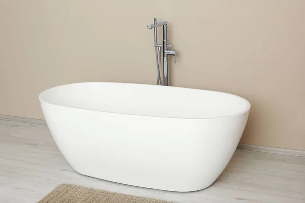 Banyoda Bej Duvarın Yanında Güzel Beyaz Bir Küvet Tasarım — Stok fotoğraf