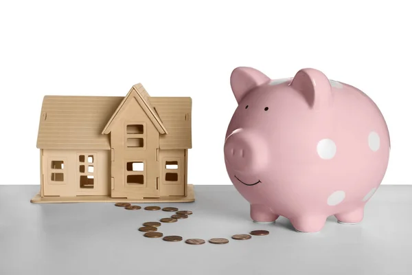 豚の銀行 白い背景に木製の家のモデルとコイン お金の概念を — ストック写真