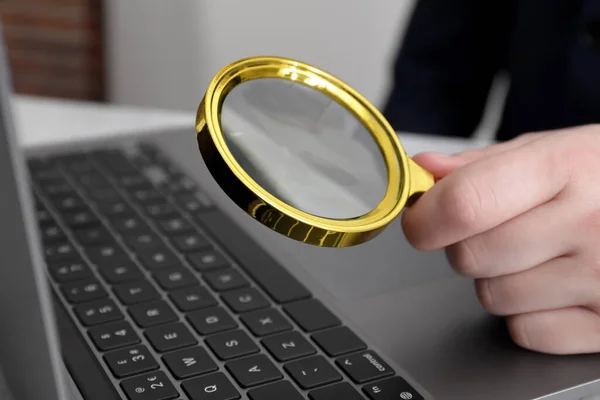 男人拿着放大镜靠近笔记本电脑在桌上 网上搜索概念 — 图库照片