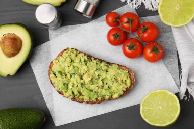 Guacamole soslu lezzetli sandviç, domates ve limonlu gri ahşap masa, düz uzanmış