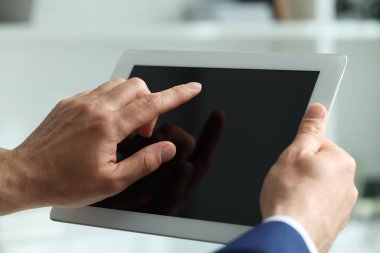 Kapalı alanda yeni tablet kullanan adamın yakın görüntüsü