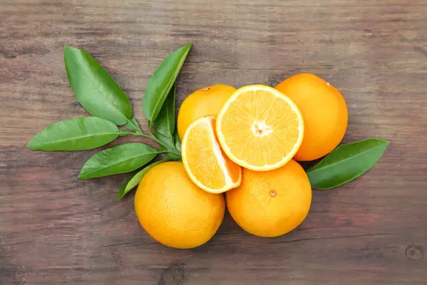 Viele Reife Orangen Und Grüne Blätter Auf Holztisch Flach Gelegt — Stockfoto