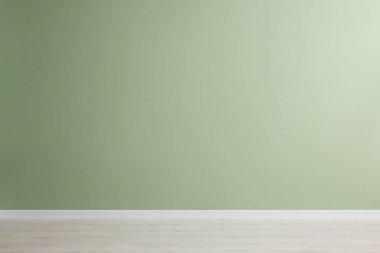 Yeşil duvarlı ve ahşap zeminli boş oda