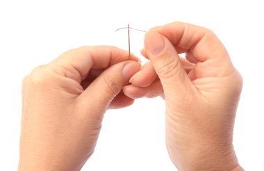 Woman threading sewing needle on white background, closeup